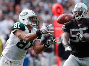 New York Jets tight end Dustin Keller (L) catches a pass in front of Oakland Raiders linebacker Rolando McClain during their NFL football game in Oakland, California September 25, 2011. (REUTERS/Robert Galbraith)