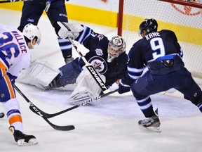 Ondrej Pavelec makes the save as New York Islanders' Tim Wallace (36) and Jets' Evander Kane (9) reach for the rebound during the first period. (FRED GREENSLADE/Reuters)