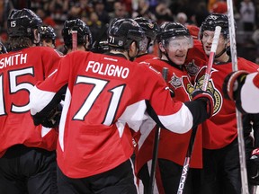 Ottawa Senators mob captain Daniel Alfredsson after he scored his 400th career goal to defeat the Calgary Flames in overtime at Scotiabank Place in Ottawa. Friday December 30,2011. (ERROL MCGIHON/THE OTTAWA SUN