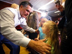 Republican presidential candidate and former Massachusetts Governor Mitt Romney greets two girls in the audience at a campaign stop in Council Bluffs, Iowa January 1, 2012, ahead of the Iowa Caucus January 3, 2012. (REUTERS/Brian Snyder)