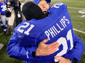 New York Giants head coach Tom Coughlin hugs New York Giants strong safety Kenny Phillips after defeating the Dallas Cowboys following their NFL football game in East Rutherford, New Jersey, January 1, 2012. (REUTERS/Ray Stubblebine)
