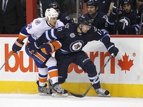 Winnipeg Jets RW Eric Fehr battles along the boards with New York Islanders centre Marty Reasoner during National Hockey League action at MTS Centre on Tuesday, Dec. 20, 2011. (Jason Halstead, Winnipeg Sun)