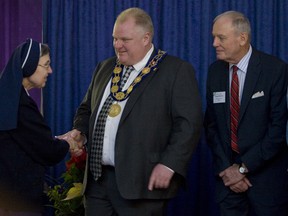 Sister Victoria of the Sisters Servants of Mary Immaculate shakes hands and gives her blessing to Toronto Mayor Rob Ford and Deputy Mayor Doug Holyday at the 2012 New Year's levee. (JACK BOLAND/Toronto Sun files)