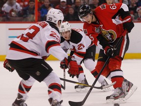 Ottawa Senator Erik Karlsson gets tries to get past the New Jersey Devils during first period action Monday night in Ottawa.    Tony Caldwell/Ottawa Sun