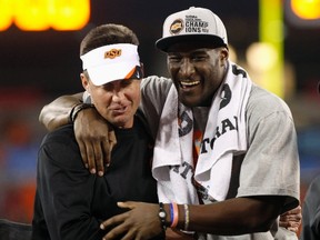 Oklahoma State head coach Mike Gundy, left, hugs wide receiver Justin Blackmon after defeating the Stanford Cardinal, to win the  2012 Fiesta Bowl in Glendale, Arizona January 2, 2012. (REUTERS/Rick Scuteri)