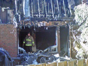 A fire investigator examines the interior of a townhome destroyed by an early-morning fire on Tuesday, Jan. 3, 2012. The $750,000 blaze at 3520 Downpatrick Rd. left five people homeless. (LARISSA CAHUTE Ottawa Sun)