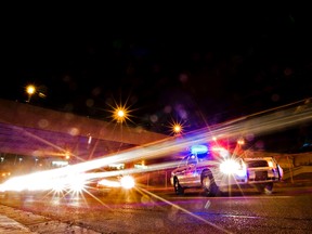 Traffic flows past police cruisers during an Edmonton CheckStop. (AMBER BRACKEN/EDMONTON SUN FILE)