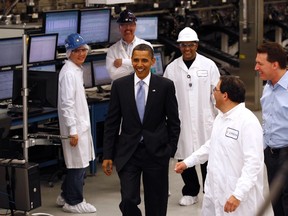 U.S. President Barack Obama (C) talks with workers as he tours Solyndra, Inc., a solar panel manufacturing facility in Fremont, California, in this May 26, 2010 file photo. (REUTERS/Kevin Lamarque/Files)