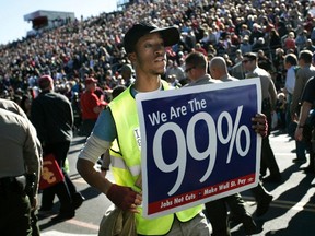 Members of Occupy The Rose Parade march down Colorado Boulevard during the "We The People" demonstration immediately following the last official entry in the Rose Parade in Pasadena, California, January 2, 2012. (REUTERS/Jonathan Alcorn)