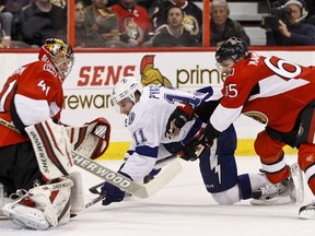 Ottawa Senator Erik Karlsson checks Tampa Bay Lightning Tom Pyatt as Sens netminder Craig Anderson makes the save during second period NHL hockey action at Scotiabank Place in Ottawa. Thursday January 5,2012. (ERROL MCGIHON/THE OTTAWA SUN).