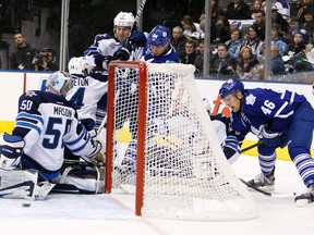 Leafs Joey Crabb (right) puts one through Jets goalie Chris Mason during Winnipeg’s 4-0 loss against Toronto Thursday night. With their second straight defeat on the road, the Jets are in danger of sinking their promising season. (DAVE ABEL/QMI Agency)