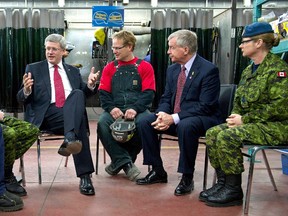 Prime Minister Stephen Harper chats with boilermakers and Canadian soldiers prior to announcing support for Helmets to Hardhats, a program that will help Canadian Forces veterans access to a range of careers in the trades in Edmonton, January 6, 2012. Pictured (L-R) are Robert Fenton, Captain Andrew Ferguson, Stephen Harper, Gary Wagner, Tory MP Laurie Hawn, and Master Corporal Roberta Paterson. REUTERS/Chris Schwarz