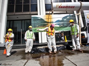 Greenpeace activists set up a mock oil spill to protest Enbridge's Northern Gateway pipeline application in Vancouver in this July 28, 2010 file photo. (QMI Agency files)