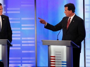 Republican presidential candidate former U.S. Senator Rick Santorum, right, speaks as former Massachusetts Governor Mitt Romney, left, listens, in a Republican presidential debate at St. Anselm College in Manchester, New Hampshire, January 7, 2012. (REUTERS/Mike Segar)