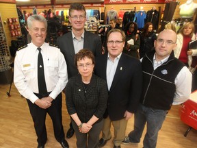 Winnipeg Police Chief Keith McCaskill (from left), Justice Minister Andrew Swan, Coun. Scott Fielding and Const. Nick Paulet stand behind Linda Howes, a volunteer board director for the Canadian Cancer Society. The group announced the upcoming 8th Annual Cops For Cancer half-marathon at the Running Room on Grant Avenue Friday. (CHRIS PROCAYLO/Winnipeg Sun)