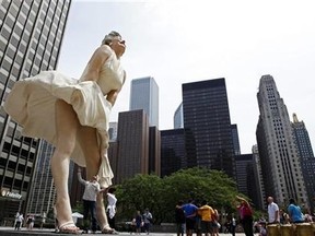 A man jokingly looks under the dress of a 26-foot tall statue of Marilyn Monroe in Chicago, July 15, 2011. (Reuters/Jim Young)