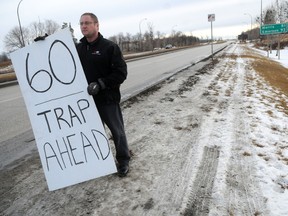 Despite the city tearing down Wise Up Winnipeg's sign warning drivers to avoid speeding past the St. Norbert Bridges, founder Todd Dube was out at the site again on Tuesday, Jan. 10, 2012. (JAMES TURNER/Winnipeg Sun)