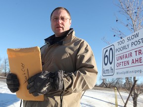 Wise Up Winnipeg founder Todd Dube unveiled a sign on Monday, Jan. 9, 2012 to warn motorists southbound on Highway 75 out of St. Norbert about the 60 km/h speed limit and possible speed-traps. The city tore it down that same day. (Jason Halstead, Winnipeg Sun)