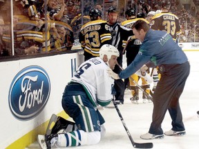 Sami Salo of the Vancouver Canucks is helped off the ice after he was hit by Bruins Brad Marchand (63) on Saturday, Jan. 7, 2012. The threats that came later evoke ugly memories of what happened to Colorado’s Steve Moore. (AFP-Getty Images)