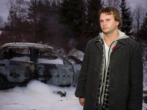 Joe Raczkowski from Cobourg pulled the taxi driver from the burning vehicle (behind him) in Hamilton Township on January 10, 2012. (Pete Fisher/Nesphotos.ca)