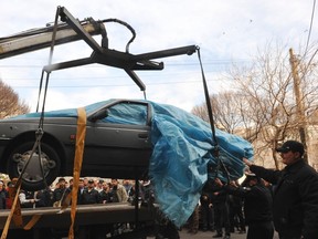 The car belonging to Iranian nuclear scientist Mostafa Ahmadi-Roshan is lifted at a blast site outside a university in northern Tehran January 11, 2012. (REUTERS/IIPA/Sajad Safari)