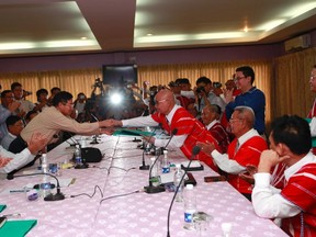 The Myanmar government’s peace negotiator, Minister of Rail Transport Aung Min, left,, shakes hands with General Mutu Saipo from the Karen National Liberation Army (KNU) after signing a ceasefire agreement at Hotel Zwekabin in Pa-an, capital of the Karen State in eastern Myanmar January 12, 2012. (REUTERS/Soe Zeya Tun)