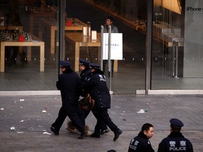 A woman is dragged away by police after she refused to leave from the front of the Apple store in the Beijing district of Sanlitun January 13, 2012. (REUTERS/David Gray)