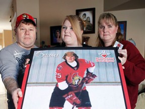 January 14, 2012  - From left, Pat Leighton, his daughter, Kaitlyn, and wife Sheri, pose with a picture of their late son Eric, who was killed during an accident at school last year. Eric Leighton’s family launched the inaugural I Love to Play Hockey program, which provides less fortunate children with hockey equipment and hockey lessons. (DARREN BROWN/QMI AGENCY)