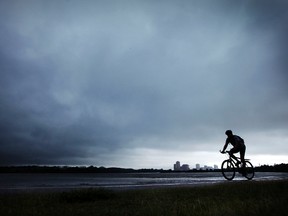 A cyclist rolls along the Ottawa River Parkway bicycle path just as a storm rolls across the Ottawa River into Ottawa from Quebec Friday, June 24, 2011. Rain is expected to continue through the weekend.  (DARREN BROWN/OTTAWA SUN)