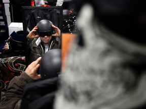 Craig Kennedy, left, checks out his reflection while trying on a helmet at the 2012 Ottawa International Motorcycle Show at the CE Centre Saturday, January 14, 2012. (DARREN BROWN/Ottawa Sun)