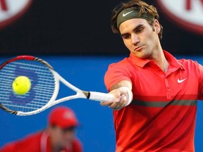 Roger Federer hits a return to Alexandre Kudryavtsev during their men's singles match at the Australian Open in Melbourne on Monday, Jan. 16, 2012. (REUTERS/Tim Wimborne)