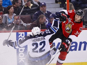 Ottawa Senator Matt Carkner checks Winnipeg Jets Chris Thorburn during second period NHL hockey action at Scotiabank Place on Monday January 16,2012. (ERROL McGIHON/THE OTTAWA SUN/QMI AGENCY).