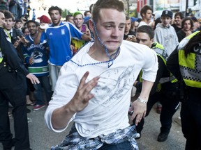 A man evades the police after a riot breaks out in downtown Vancouver, June 15, 2011. (Carmine Marinelli/QMI Agency)