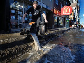Cold temperatures caused a watermain to break on Elgin Street in Ottawa Wednesday, Jan. 18,  2012. A worker from the store Vanilla on Elgin Street, gets rid of some water that was on their floor Wednesday.    
(TONY CALDWELL/OTTAWA SUN)