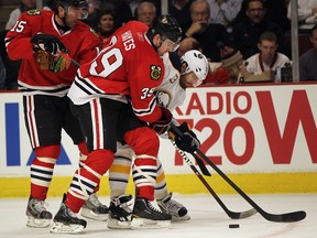 Chicago Blackhawks Jimmy Hayes battles for the puck with Buffalo Sabres Ville Leino in front of Andrew Brunette at the United Center on January 18, 2012 in Chicago, Illinois. The Blackhawks defeated the Sabres 6-2. (Jonathan Daniel/Getty Images/AFP)