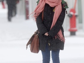A woman braces against cold weather as she walks along Portage Ave. close to the University of Winnipeg. (Winnipeg Sun)