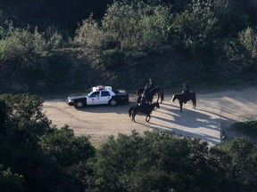 LAPD mounted police officers search a hilly area below the iconic Hollywood sign in Los Angeles, California January 18, 2012. (REUTERS/Jonathan Alcorn)