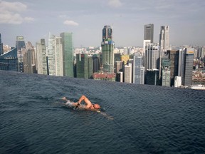 A guest swims in the infinity pool of the Skypark that tops the Marina Bay Sands hotel towers in Singapore in this June 24, 2010 file photo. REUTERS/Vivek Prakash/Files