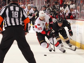 Erik Karlsson #65 of the Ottawa Senators looks to play the puck under pressure from Niklas Hagman #12 of the Anaheim Ducks in the third period during the NHL game at Honda Center on January 21, 2012 in Anaheim, California. (Victor Decolongon/Getty Images/AFP)