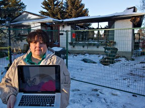 Theresea Balazs holds a photo of one of her missing cats outside her fire-devastated home in Sherwood Park, Alberta on Sunday, January 22, 2012. Balazs cats KousKous, a light grey female Siamese, and Mosely, a black and white boy with a bandit-like mask of colouring on his face, have been missing since the January 5th blaze. AMBER BRACKEN/EDMONTON SUN/QMI AGENCY