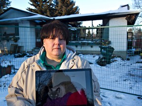 Theresea Balazs holds a photo of one of her missing cats outside her fire-devastated home in Sherwood Park Sunday. (Amber Bracken/Edmonton Sun)