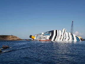 Scuba divers sit in a dinghy near the Costa Concordia cruise ship which ran aground off the west coast of Italy at Giglio island January 24, 2012. Salvage crews began preparations on Tuesday to pump thousands of tonnes of fuel from the wreck of the Costa Concordia as the search continued for bodies, 11 days after the giant Italian cruise liner struck a rock off the Tuscan coast and capsized. REUTERS/Tony Gentile