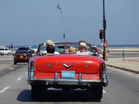 Tourists take a ride in a 1955 Desoto convertible in Havana, August 17, 2011. REUTERS/Desmond Boylan