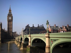 Pedestrians walk across Westminster Bridge in front of the Big Ben Clock Tower, in London in this March 8, 2011 file photo.  REUTERS/Stefan Wermuth/Files