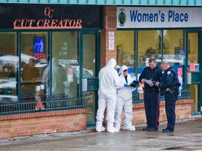 Toronto Police forensics unit officers wear protective clothing at the scene of a homicide at Cut Creator in Malvern Town Centre in Scarborough Tuesday. A man was executed by a shotgun-toting killer inside a barber shop at a Scarborough mall over the lunch hour Tuesday. (ERNEST DOROSZUK/Toronto Sun)