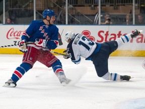 New York Rangers defenceman Dan Girardi upends Winnipeg Jets centre Kyle Wellwood (13) to stop a breakaway scoring attempt on Rangers goalie Henrik Lundqvist (R) in the second period of their NHL hockey game at Madison Square Garden in New York January 24, 2012