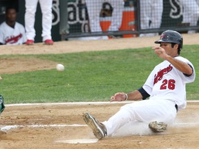 Gary SouthShore RailCats catcher Mike Valadez (left) runs for the ball as Winnipeg Goldeyes center fielder Ridge Carpenter slides safely home during American Association play Aug. 1, 2011. (BRIAN DONOGH/Winnipeg Sun)