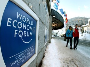 People walk past the logo of the World Economic Forum (WEF) in front of the congress center in the Swiss mountain resort of Davos January 22, 2012. The WEF takes part at the congress center from January 25 to 29.    REUTERS/Arnd Wiegmann