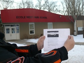 Rachael Friesen holds a copy of the Ally pledge — which says, among other things, "I support lesbian, gay, bisexual, transgender, Two-Spirit, intersex, queer and questioning individuals, families and communities" — in front of West Park School in Altona, Man., in January 2012. Friesen is among a group parents upset the school has told a Grade 5 teacher to take down the pledge on the grounds it isn't age-appropriate. (LORI PENNER/Red River Valley Echo)
