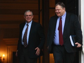 Greece's Prime Minister Lucas Papademos escorts Finance Minister Evangelos Venizelos after a meeting in Athens January 28, 2012. Greece and its private creditors head back to the negotiating table on Saturday to put together the final pieces of a long-awaited debt swap agreement needed to avert an unruly default.  REUTERS/John Kolesidis